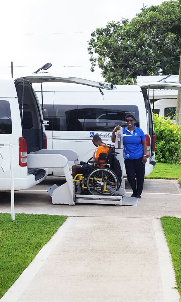 Blessed Rentals team assisting a wheelchair user with an accessible vehicle lift